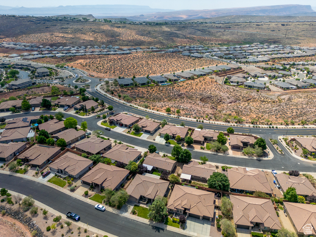 Aerial overview of property's location with a mountainous background and nearby suburban area