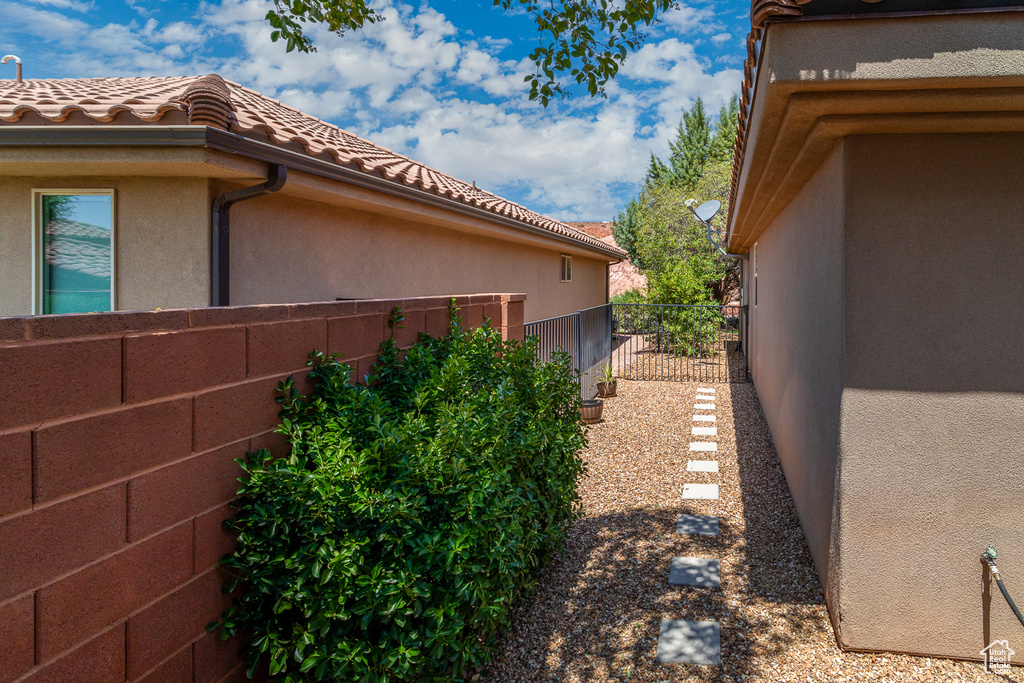 View of side of property with a tile roof and stucco siding