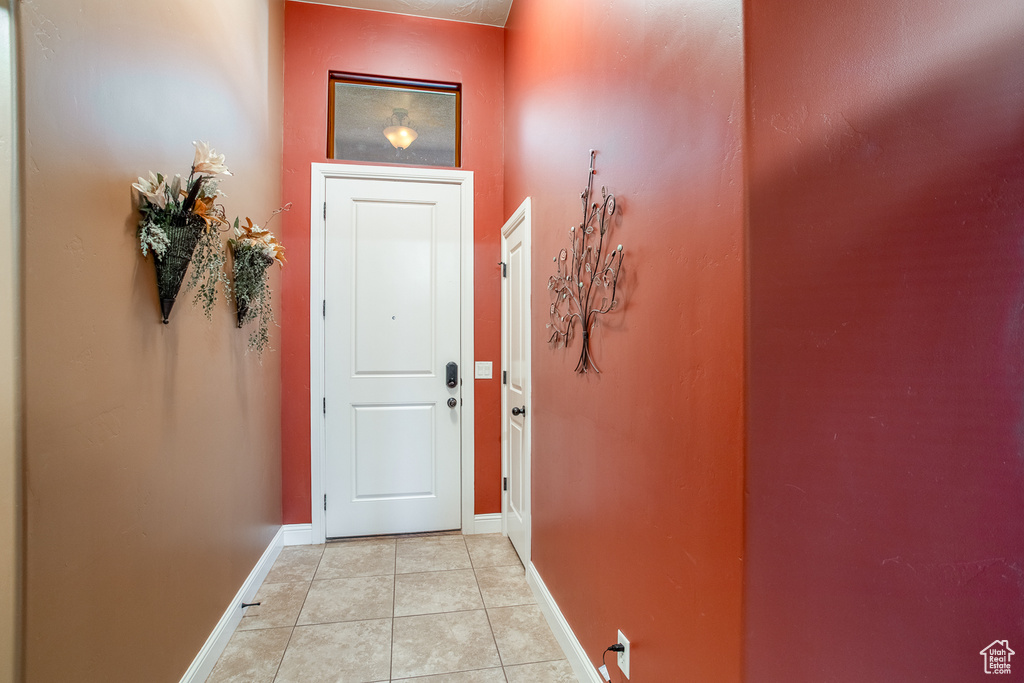 Doorway to outside with baseboards and light tile patterned floors
