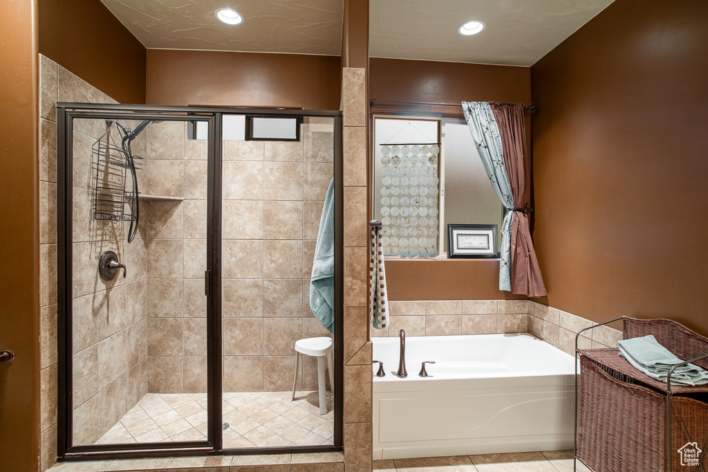 Bathroom with a bath, a stall shower, tile patterned floors, and recessed lighting
