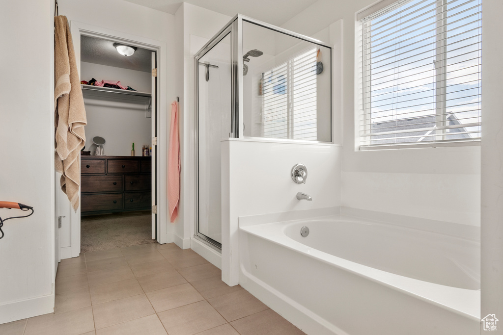 Full bath with a shower stall, a bath, healthy amount of natural light, and a spacious closet