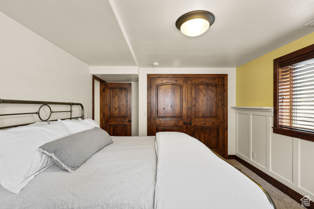 Bedroom with wainscoting and dark carpet