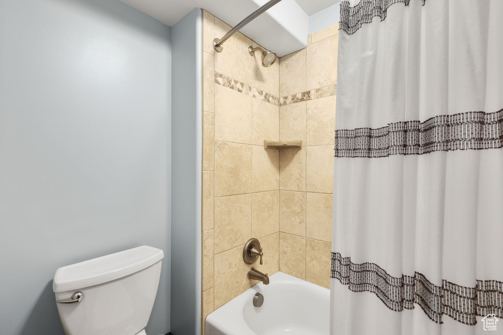 Bathroom with shower / tub combo with curtain and toilet