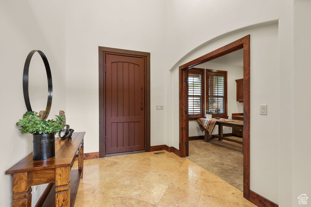 Entrance foyer with baseboards and light stone finish floors