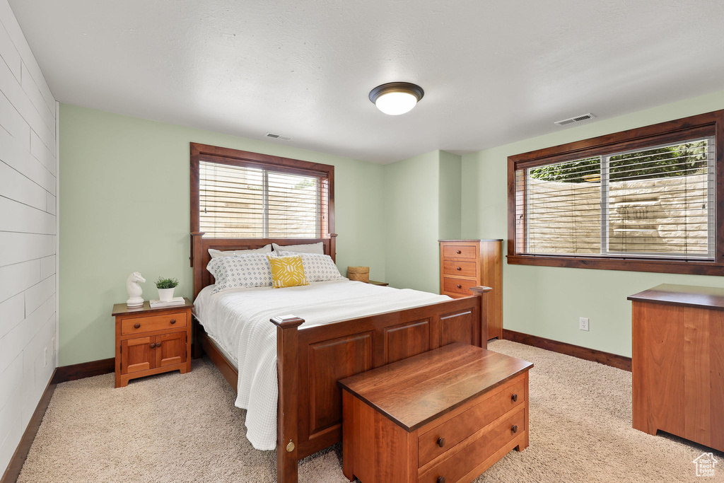 Bedroom featuring multiple windows and light colored carpet