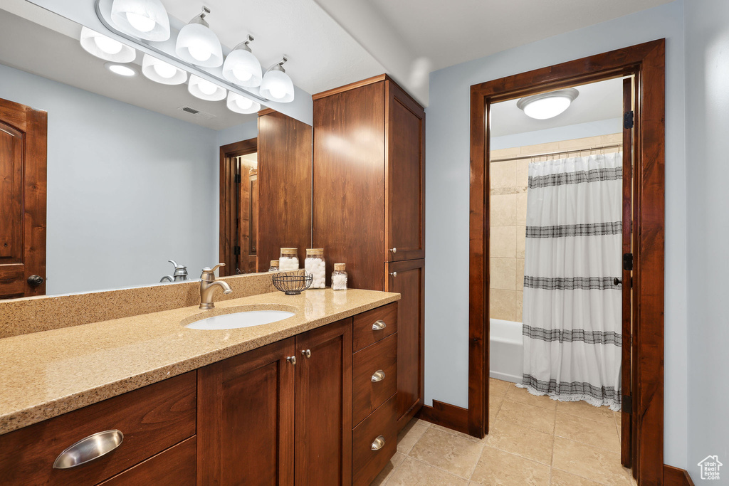 Full bathroom featuring vanity, tile patterned floors, and shower / bath combination with curtain