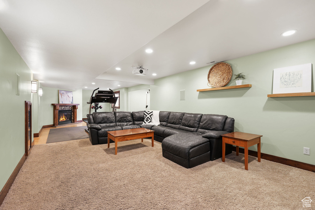 Living area featuring a glass covered fireplace, carpet floors, and recessed lighting