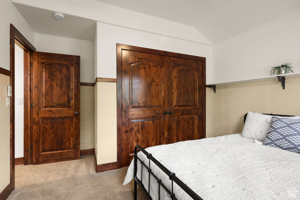 Bedroom featuring carpet floors, a closet, and lofted ceiling
