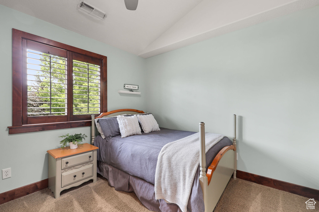 Bedroom featuring light carpet, vaulted ceiling, and ceiling fan