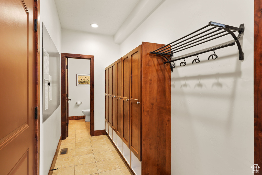 Hall with light tile patterned floors and recessed lighting