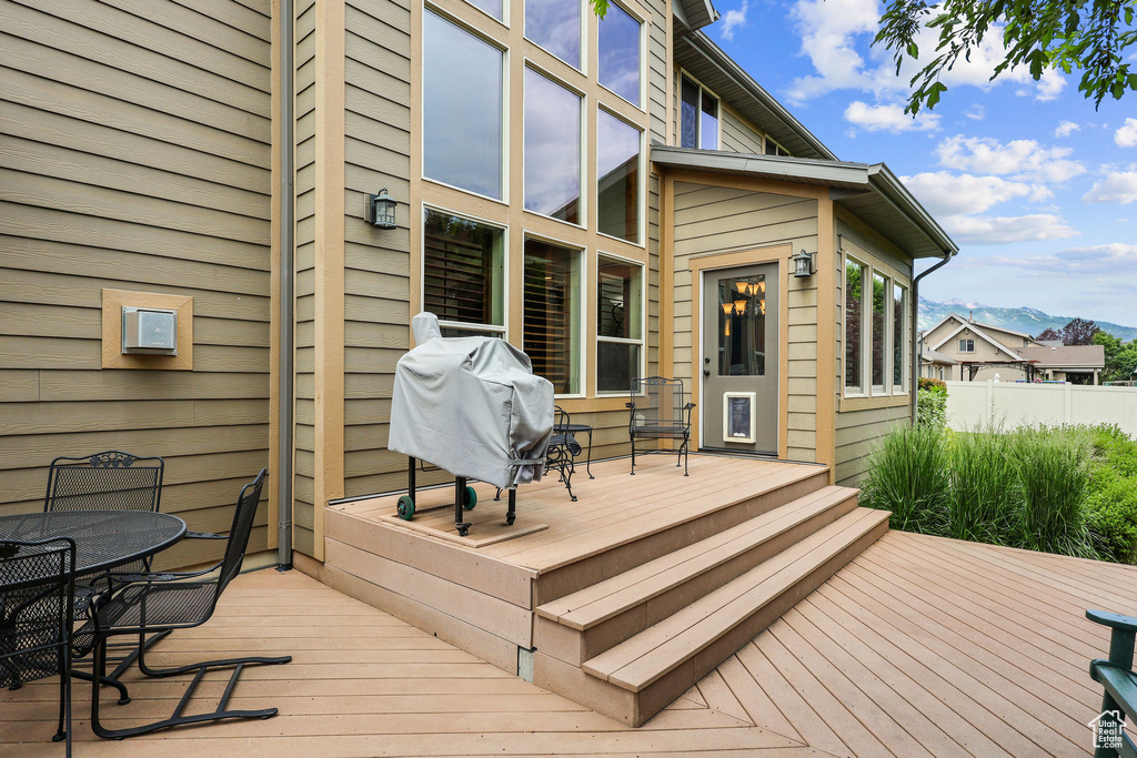 Wooden terrace with outdoor dining area, a mountain view, and area for grilling