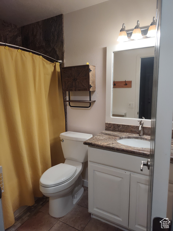 Bathroom with vanity, tile patterned floors, and a shower with shower curtain