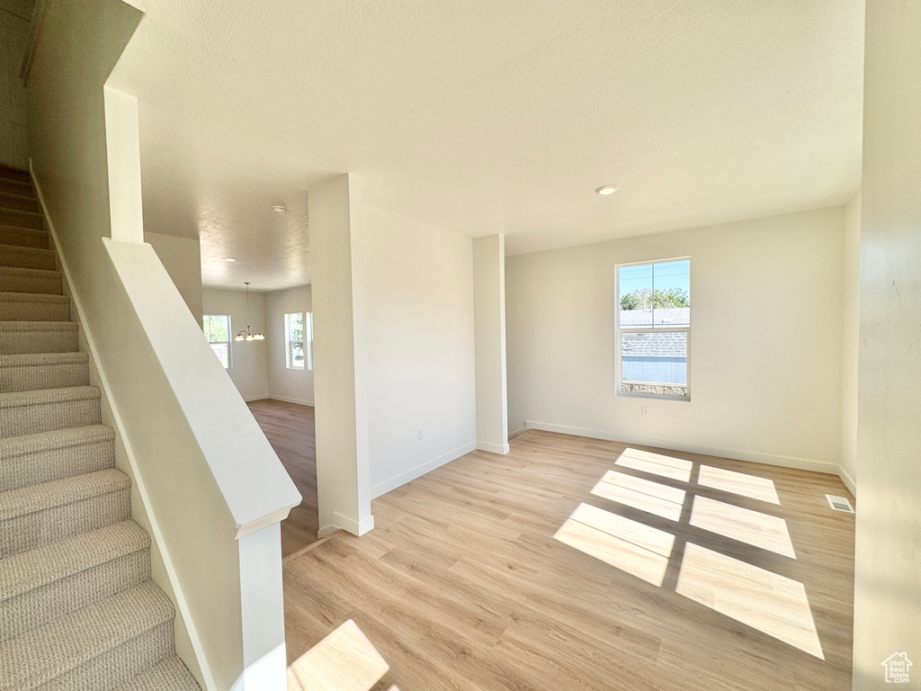 Stairway with healthy amount of natural light, wood finished floors, and recessed lighting