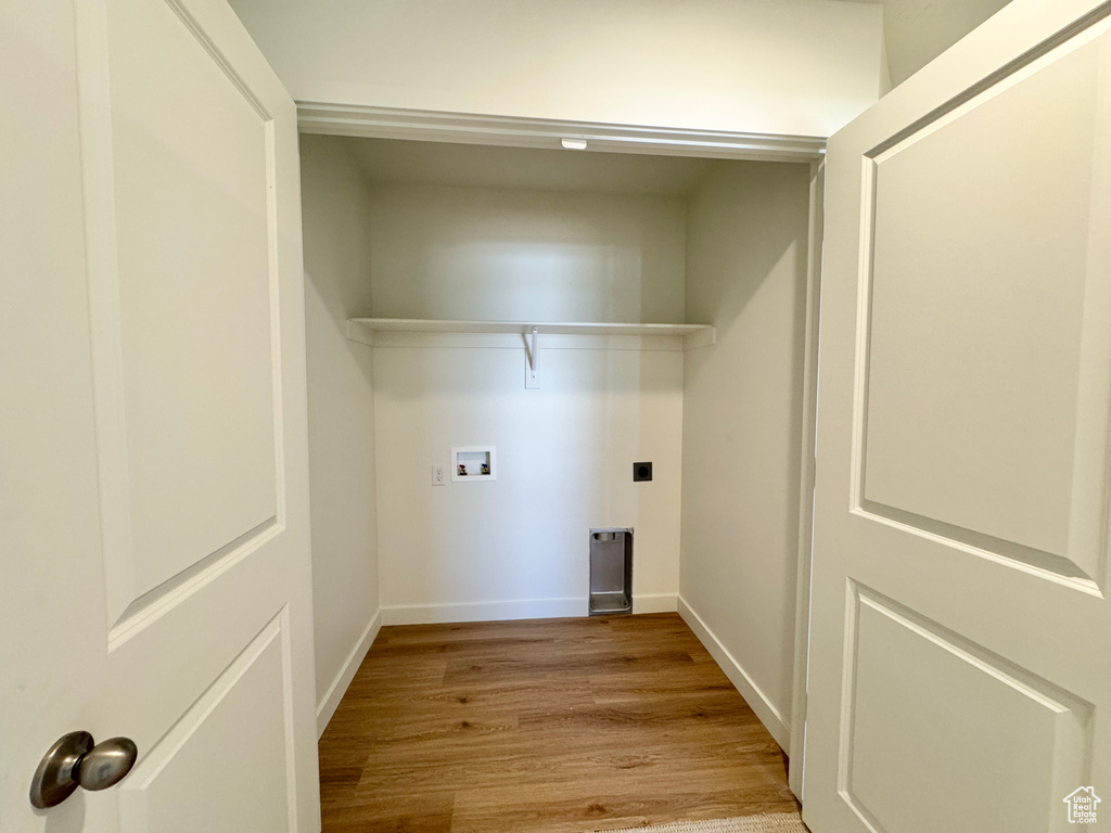 Washroom with hookup for a washing machine and wood finished floors
