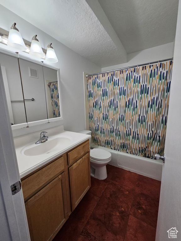 Bathroom featuring vanity, tile patterned flooring, a textured ceiling, and shower / bath combo