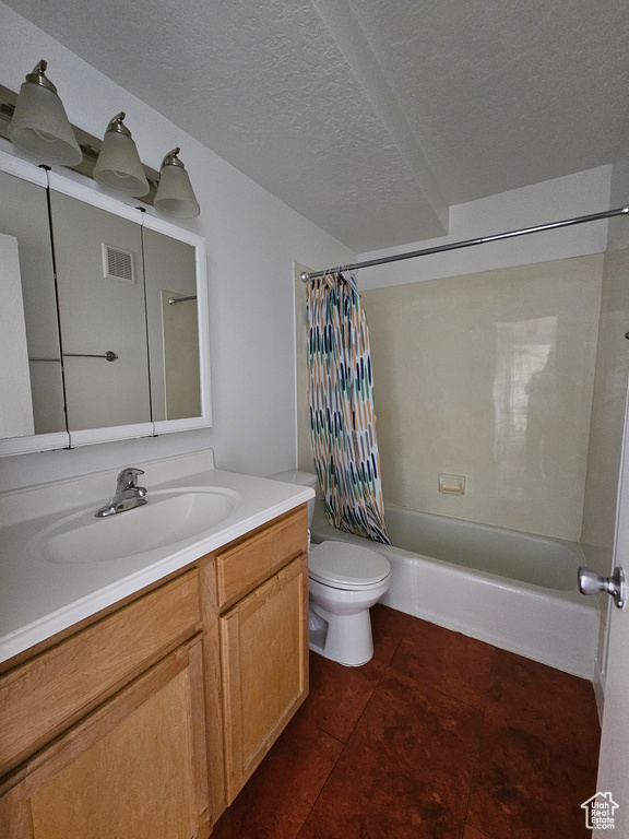 Full bath with shower / tub combo with curtain, vanity, tile patterned flooring, and a textured ceiling