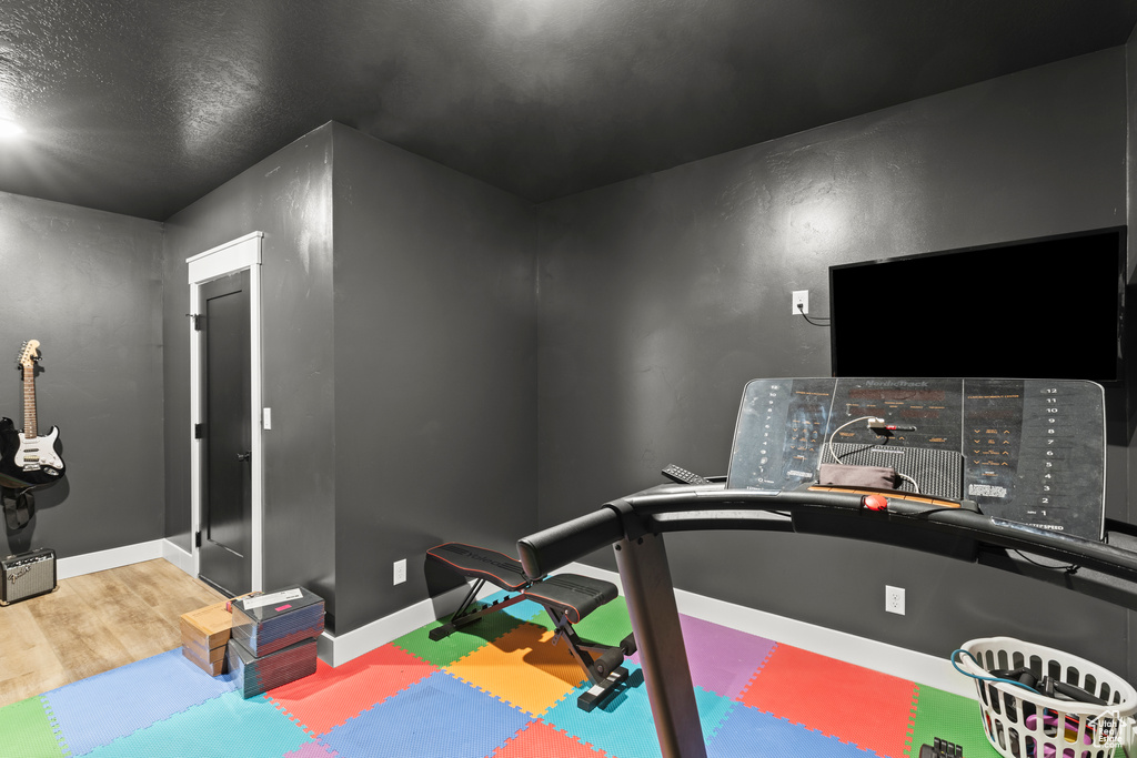 Workout room featuring baseboards and a textured ceiling