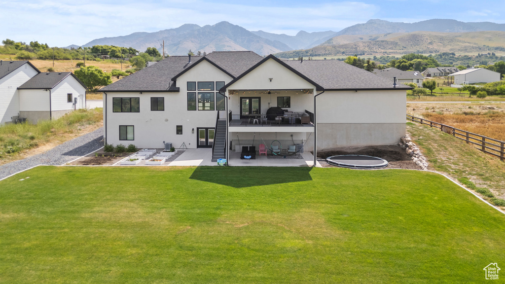 Back of property featuring a patio, ceiling fan, stucco siding, and stairs