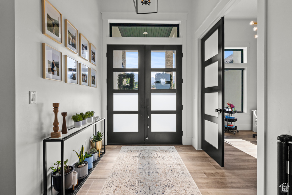 Entryway with french doors, plenty of natural light, and wood finished floors