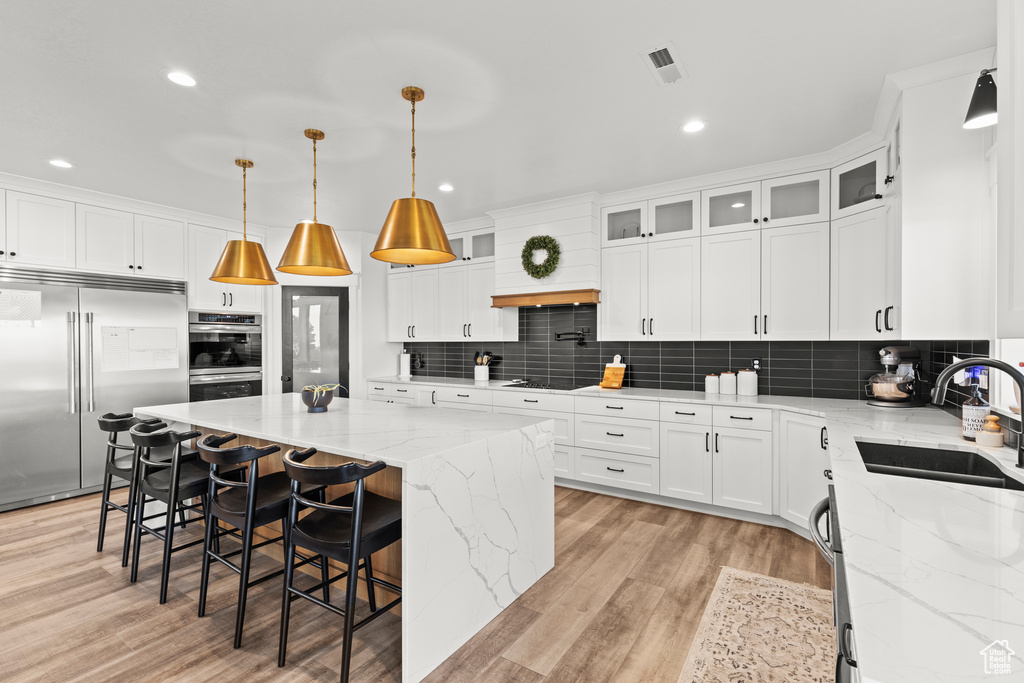 Kitchen with appliances with stainless steel finishes, a kitchen island, decorative backsplash, and recessed lighting