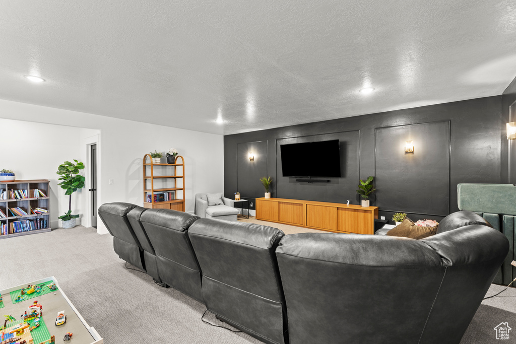 Carpeted living area featuring a textured ceiling