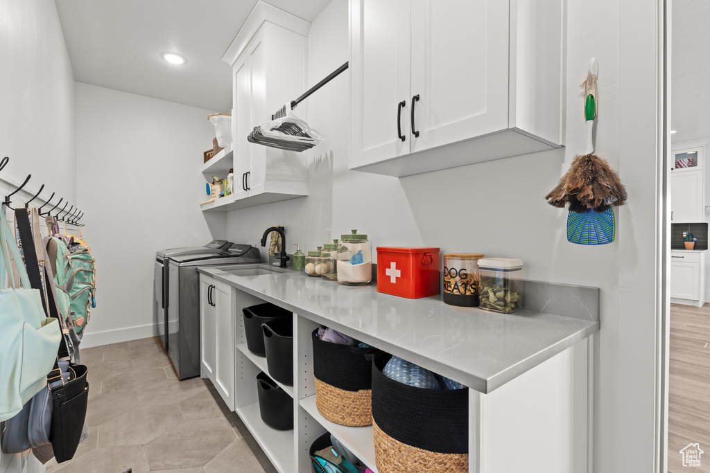 Kitchen featuring open shelves, washer and dryer, white cabinetry, light countertops, and recessed lighting