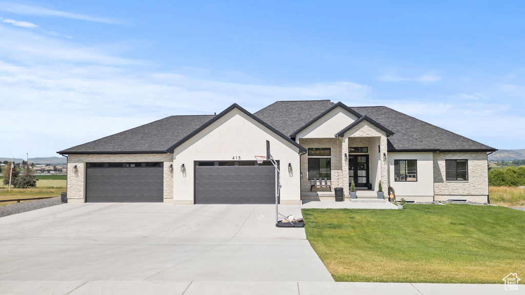 View of front facade featuring a garage, concrete driveway, a front yard, and roof with shingles