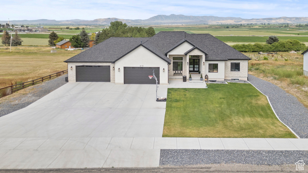 Modern farmhouse style home with an attached garage, a mountain view, driveway, and stucco siding