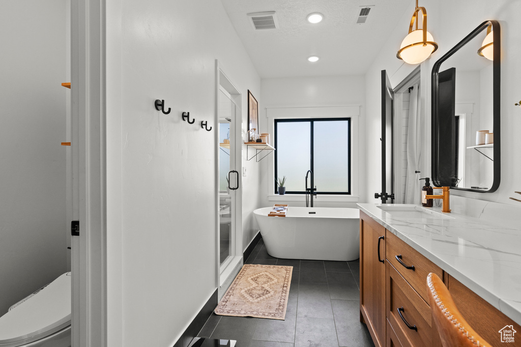 Bathroom with vanity, a shower stall, a soaking tub, tile patterned flooring, and recessed lighting