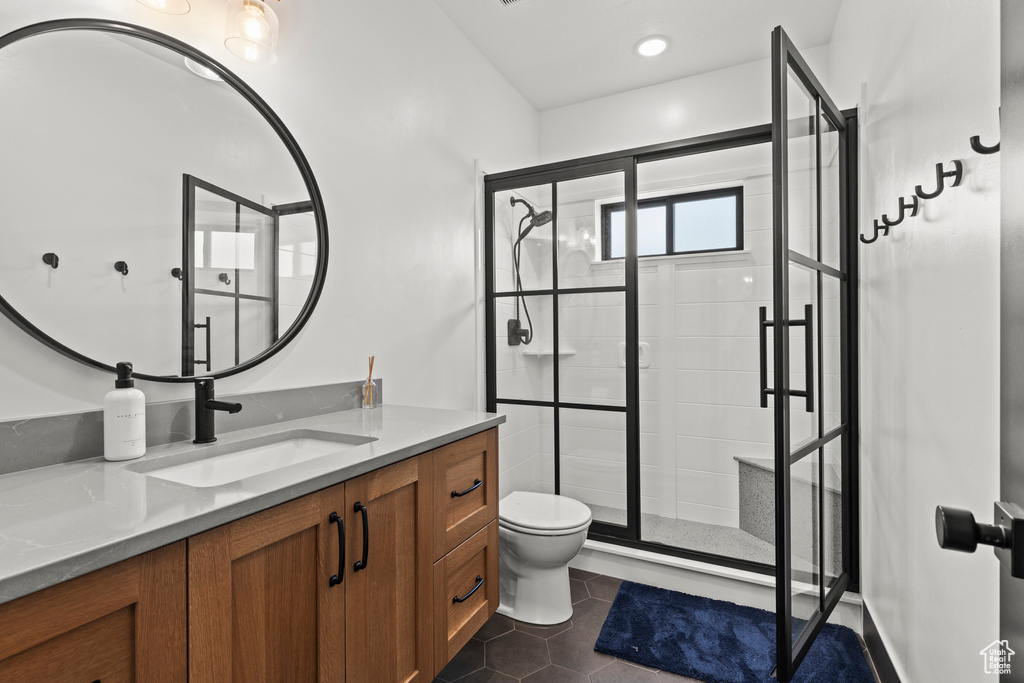 Bathroom featuring vanity, a shower stall, and tile patterned floors