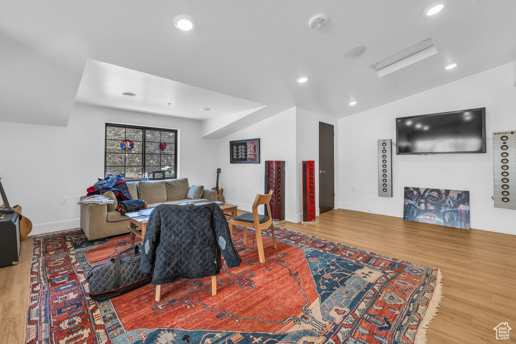 Living room featuring wood finished floors, recessed lighting, attic access, and vaulted ceiling