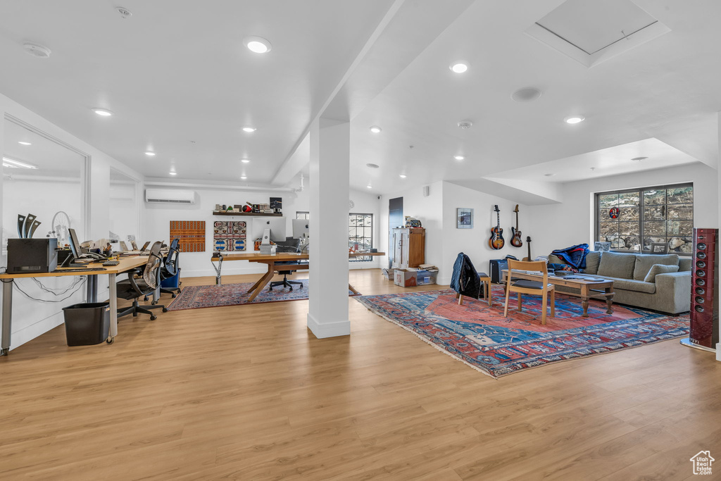 Living room featuring light wood-style floors, recessed lighting, and a wall mounted air conditioner