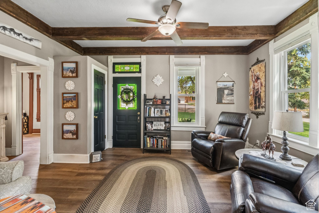Living area featuring plenty of natural light, beam ceiling, ceiling fan, and wood finished floors