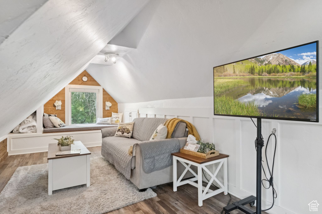 Living room featuring wood finished floors and vaulted ceiling
