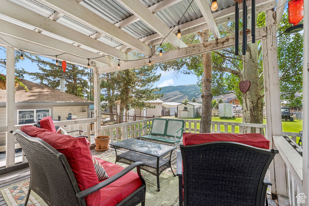 View of patio featuring an outdoor living space, a deck with mountain view, and a residential view