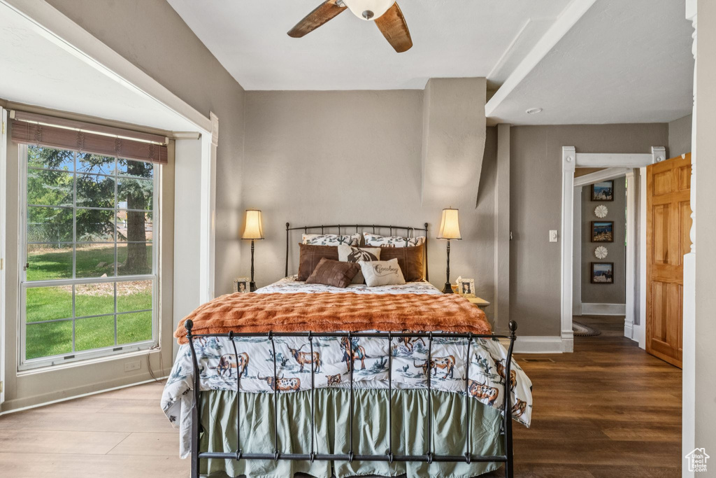 Bedroom with multiple windows, wood finished floors, and a ceiling fan