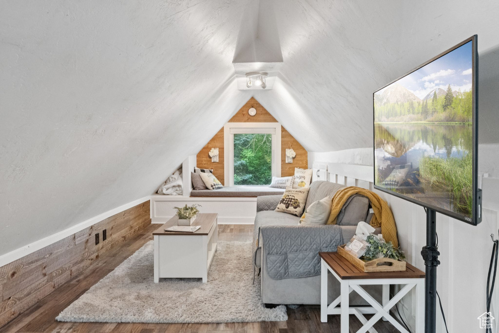 Sitting room featuring wood finished floors, lofted ceiling, and wood walls