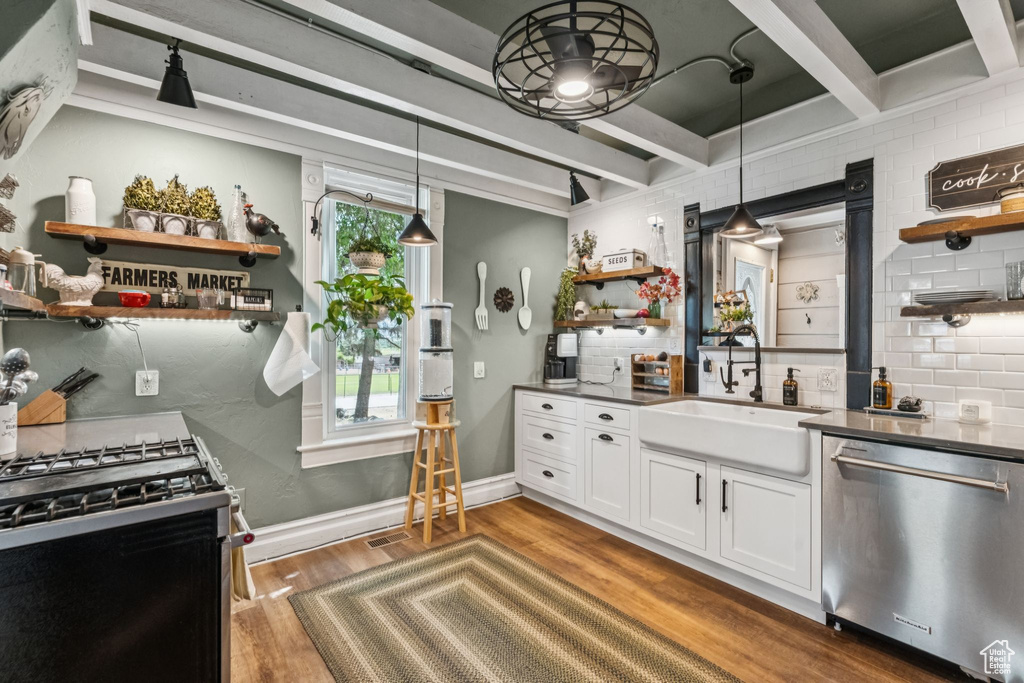 Kitchen featuring open shelves, appliances with stainless steel finishes, beamed ceiling, dark countertops, and decorative backsplash