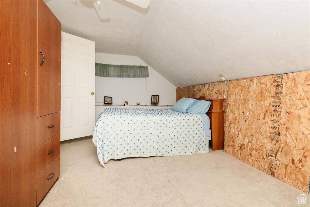 Carpeted bedroom with vaulted ceiling and ceiling fan
