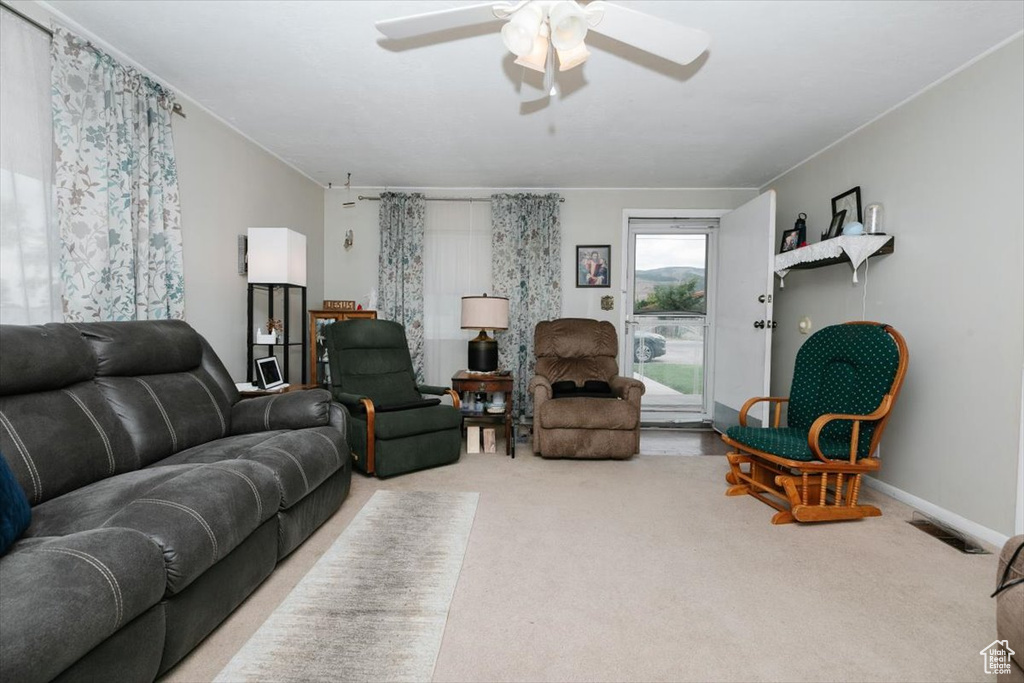 Carpeted living room featuring ceiling fan