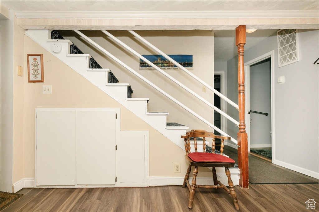 Stairs with wood finished floors and baseboards