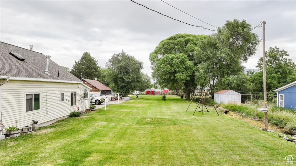 View of green lawn with a storage shed