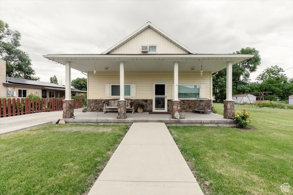 Back of house featuring a porch and stone siding