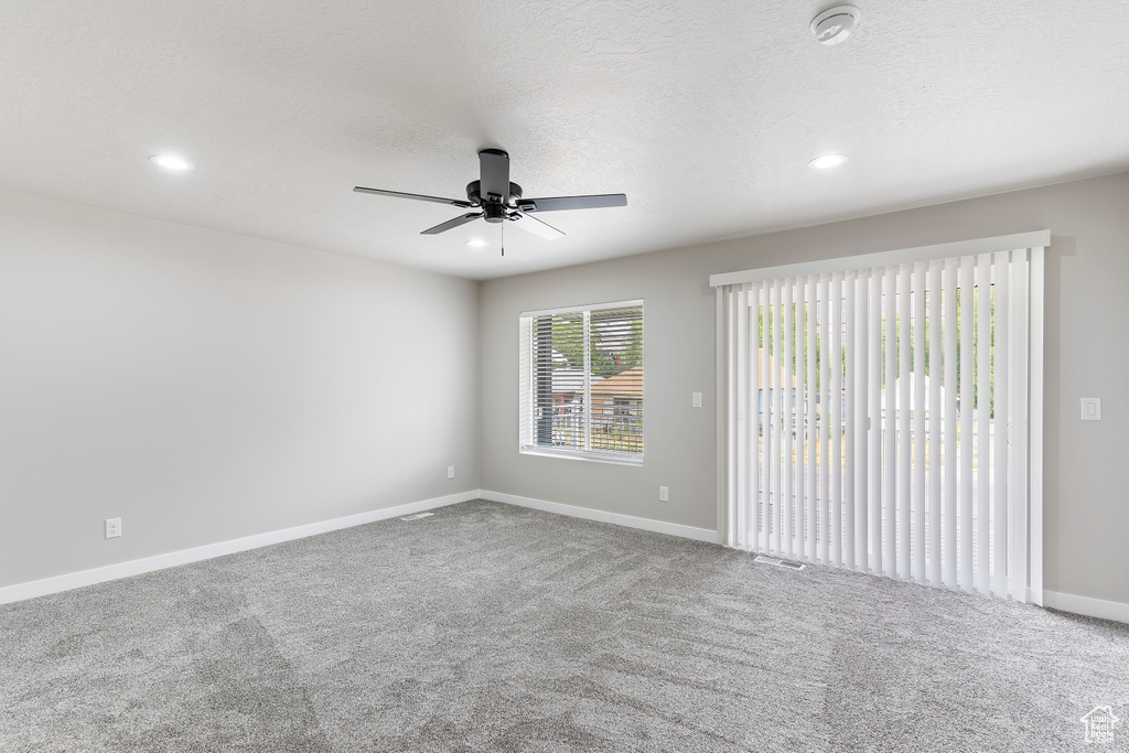 Carpeted spare room featuring a smoke detector, ceiling fan, and recessed lighting