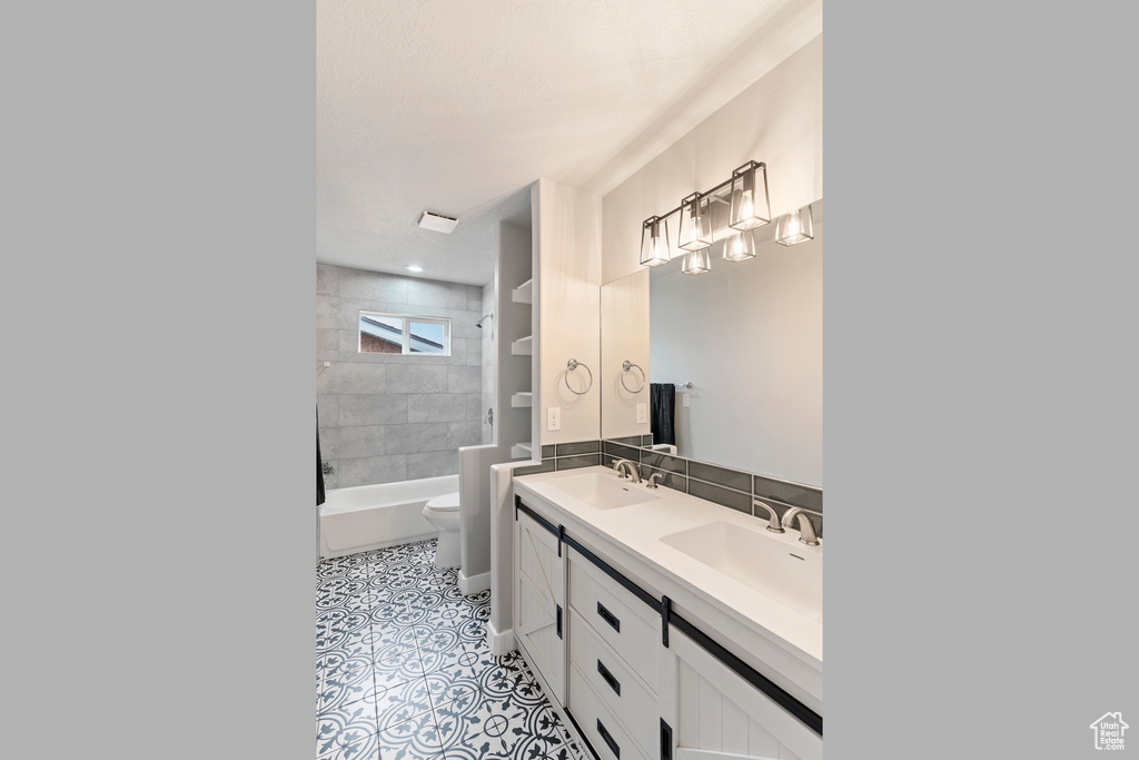 Bathroom with double vanity, bathing tub / shower combination, and tile patterned flooring