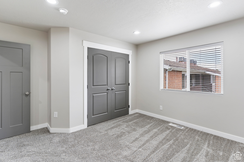 Unfurnished bedroom featuring carpet, recessed lighting, and a closet
