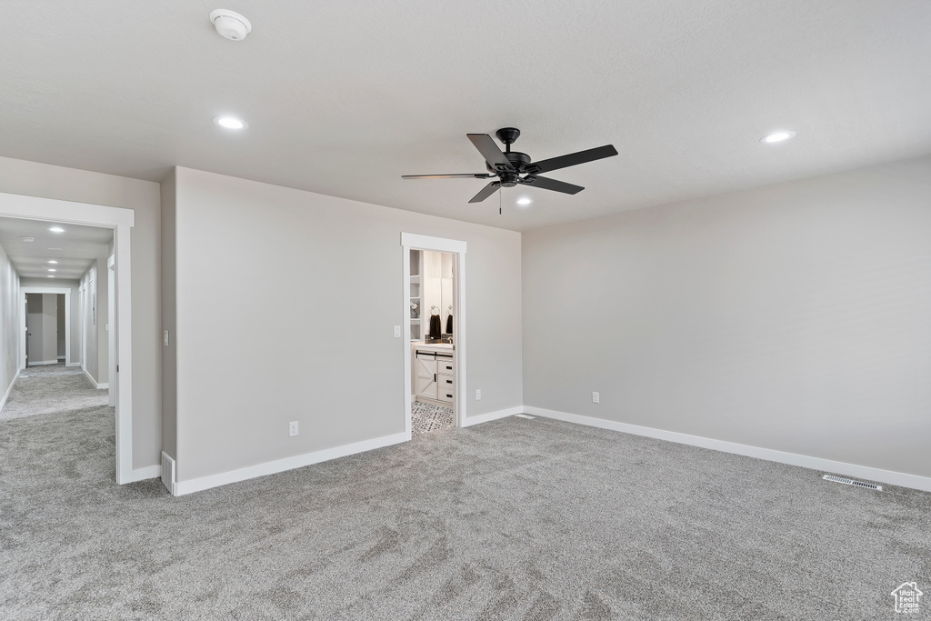 Carpeted empty room with a smoke detector, a ceiling fan, and recessed lighting