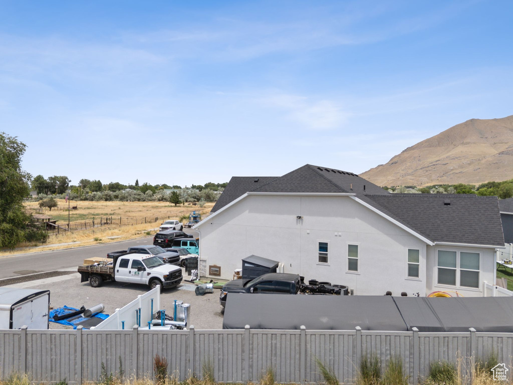 View of side of home featuring roof with shingles, a mountain view, and stucco siding