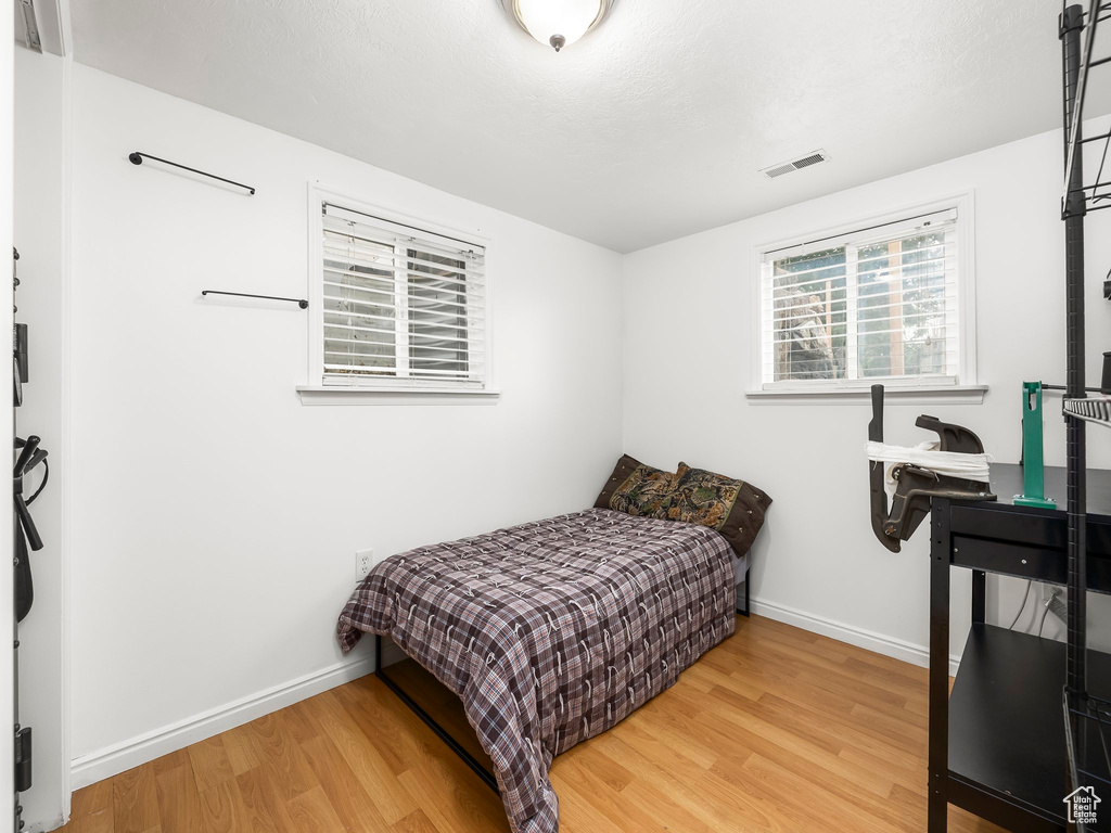 Bedroom with light wood finished floors and baseboards