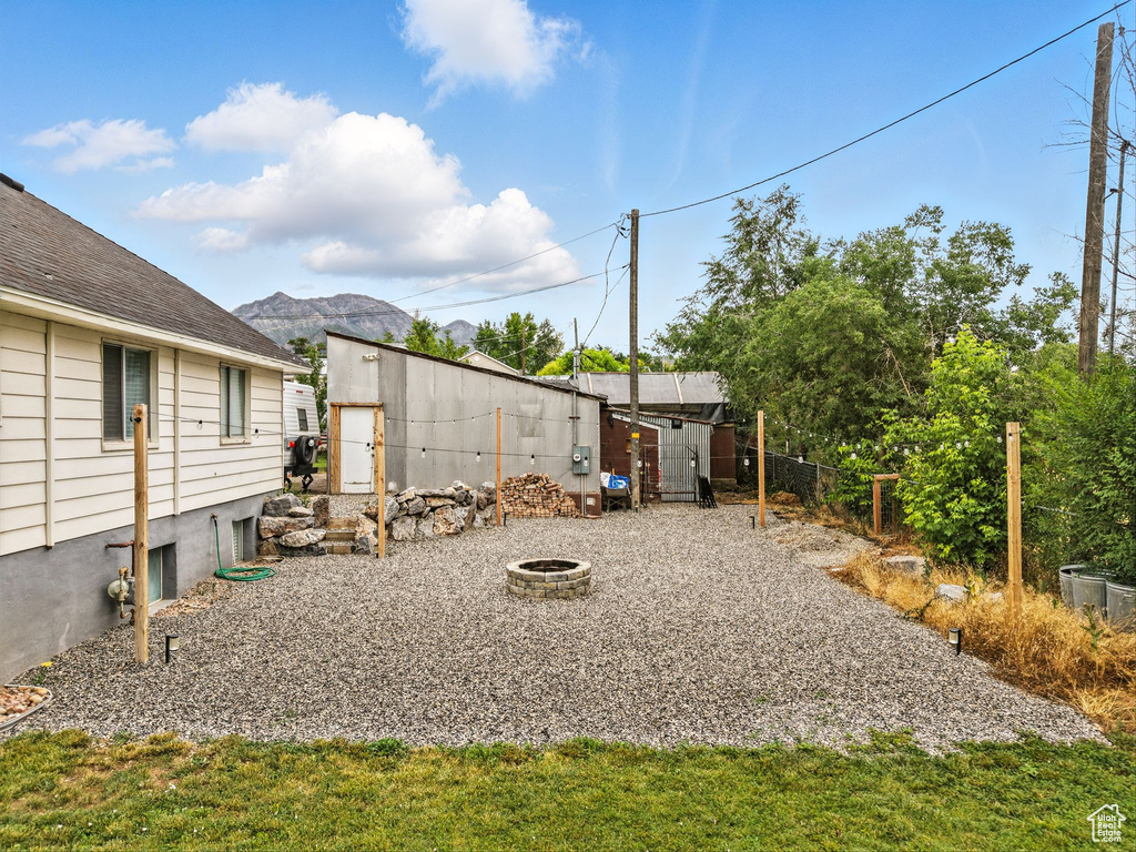 View of yard featuring a fire pit, a shed, and a mountain view